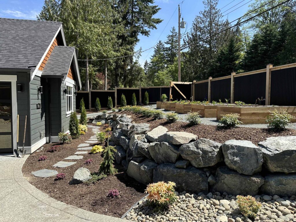 IMG_0515-scaled Landscaping example: above ground garden boxes are bordered by small shrubs. This area is raised with a stone retaining wall.