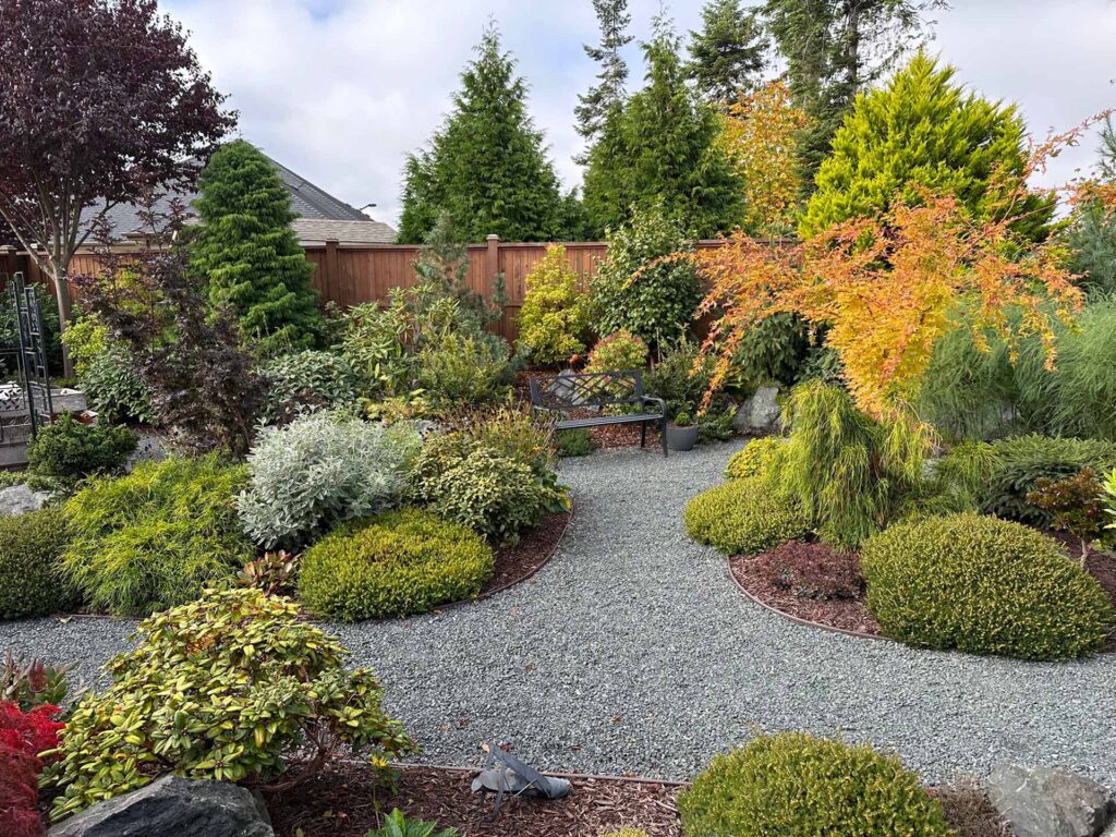 IMG_1388-scaled-1 Landscaping example: Alternative view of landscaped area with metal bench.