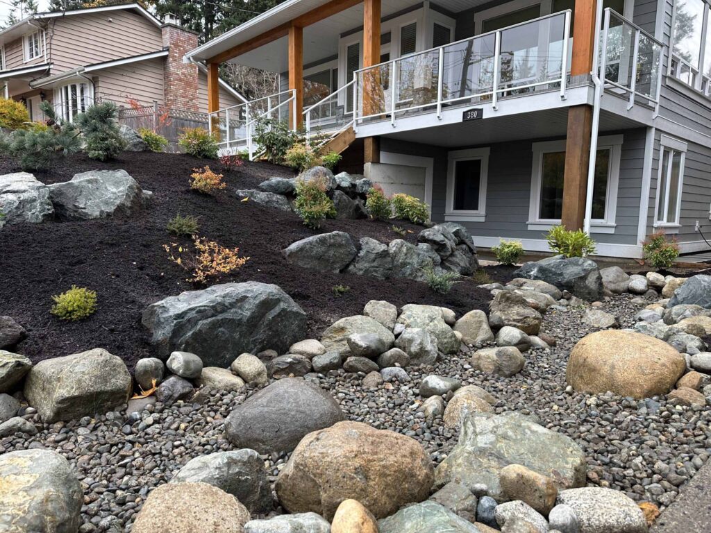 IMG_1521-scaled Landscaping example: an assortment of stones, rocks, and pebbles at the base of a landscaping project.